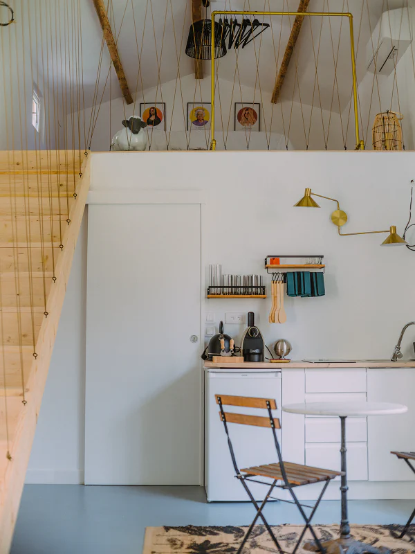 Vue de la mezzanine avec poutres apparentes et kitchenette au Château de Laubardemont