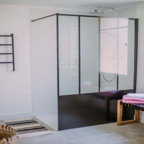 Salle de bain moderne avec douche verrière style atelier dans l'appartement du château
