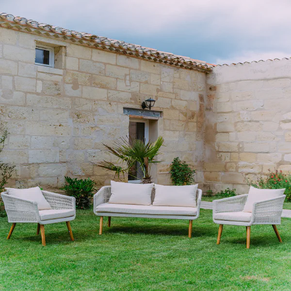 Salon de jardin blanc sur pelouse devant les murs en pierre du Château de Laubardemont