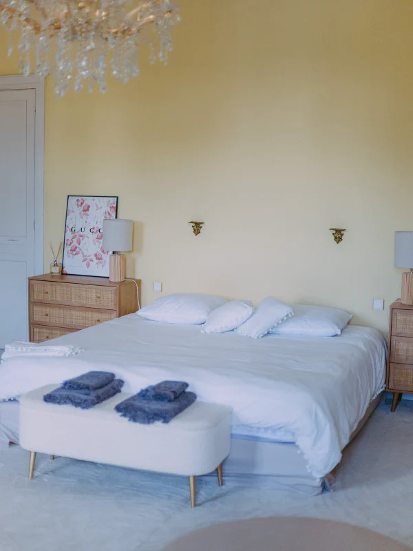 Lit king-size avec lustre cristal et commodes cannées dans la suite du château