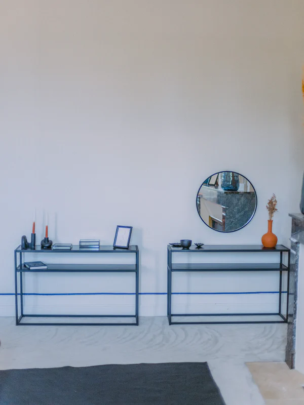 Consoles métalliques noires avec miroir rond et bougies dans la chambre du château