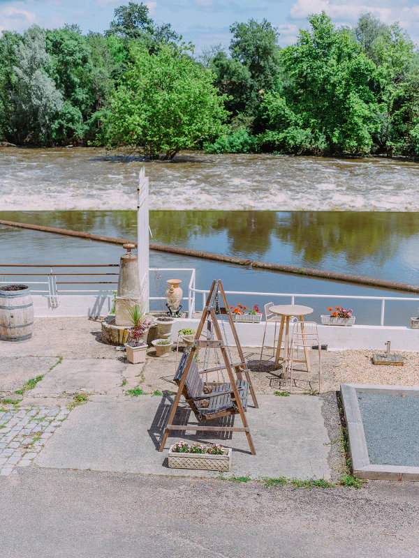 Vue sur la rivière avec terrasse fleurie et balançoire au Château de Laubardemont