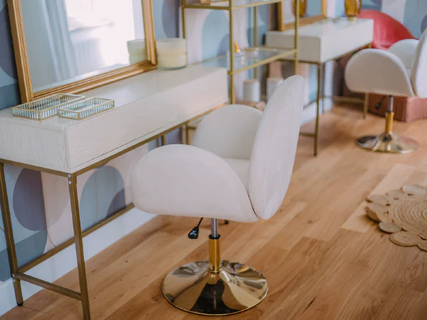 Espace coiffure de la mariée avec coiffeuse dorée et papier peint graphique au château