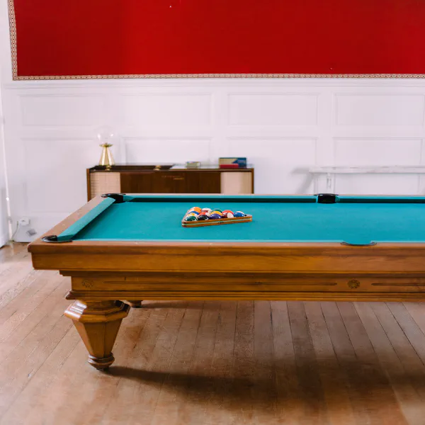 Salle de billard aux murs rouges et boiseries blanches du Château de Laubardemont